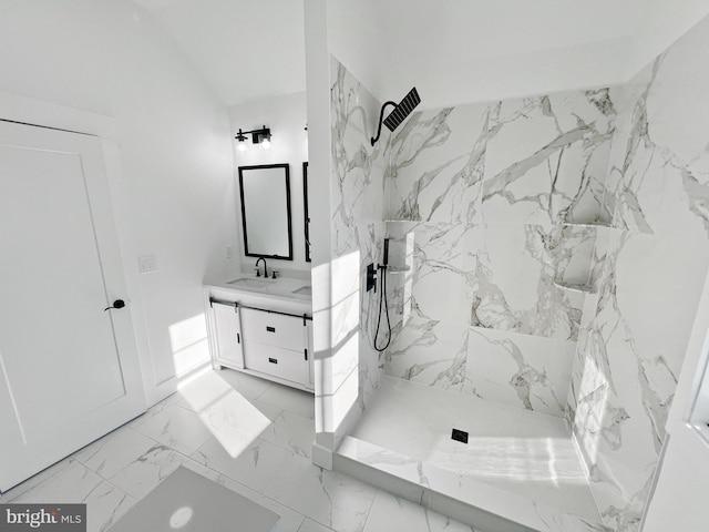 bathroom featuring vanity, lofted ceiling, and tiled shower