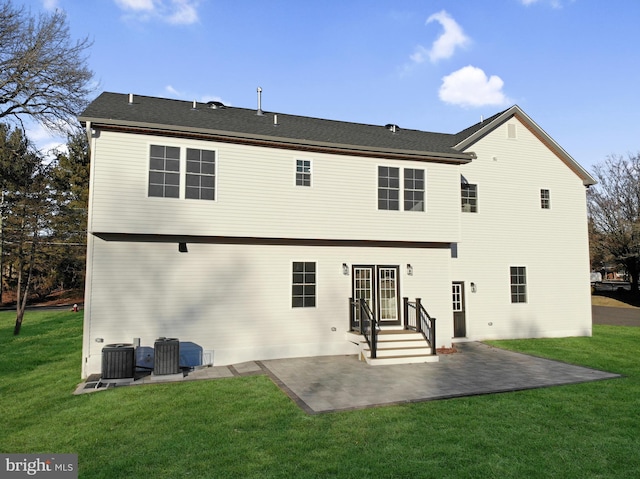 back of house featuring cooling unit, a patio area, and a lawn