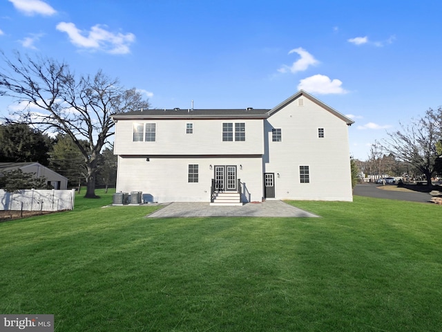 rear view of property with cooling unit, a yard, and a patio area