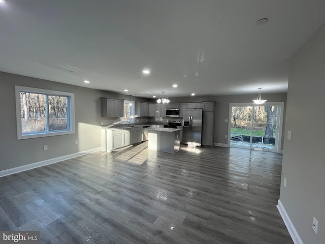 unfurnished living room featuring wood-type flooring and a notable chandelier