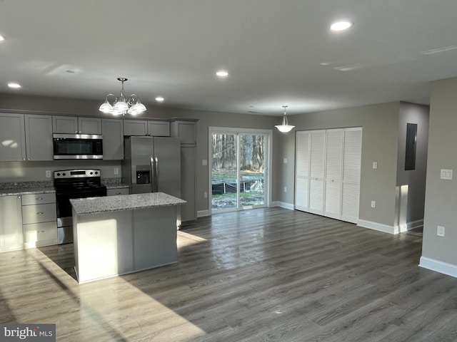 kitchen featuring hanging light fixtures, appliances with stainless steel finishes, a center island, and gray cabinetry