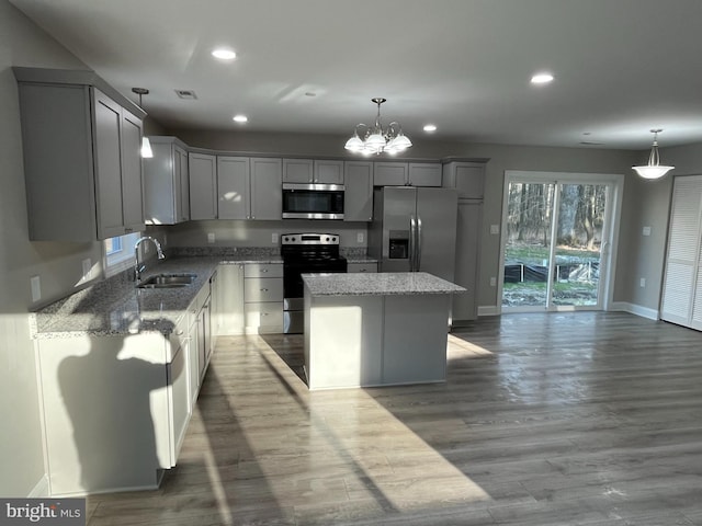 kitchen featuring a kitchen island, appliances with stainless steel finishes, sink, and pendant lighting