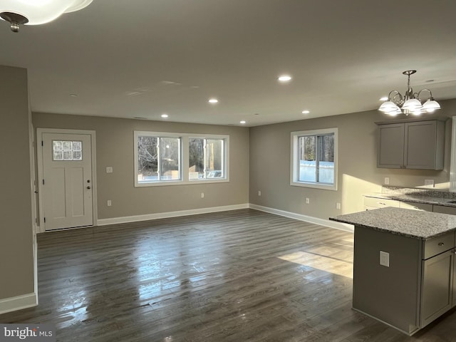 unfurnished living room featuring dark hardwood / wood-style floors and a chandelier