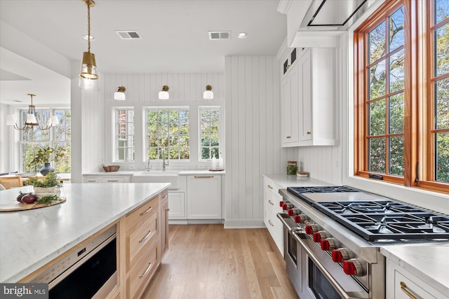 kitchen featuring a sink, double oven range, light wood-type flooring, and visible vents