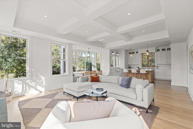 living area featuring beamed ceiling, visible vents, coffered ceiling, and light wood-type flooring