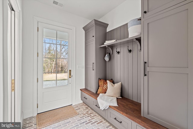 mudroom with brick floor and visible vents