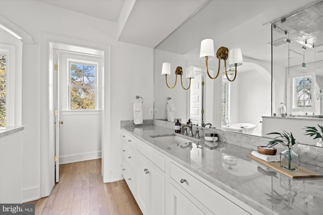 bathroom featuring vanity, wood finished floors, and baseboards