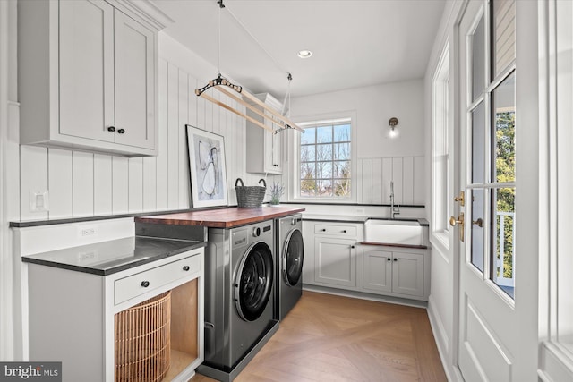 clothes washing area with cabinet space, recessed lighting, separate washer and dryer, and a sink