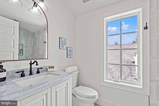 full bath with visible vents, toilet, a shower, baseboards, and vanity