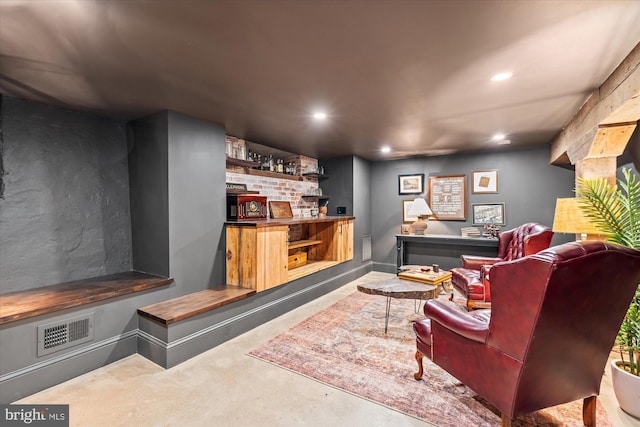 living area featuring baseboards, visible vents, recessed lighting, concrete flooring, and indoor bar