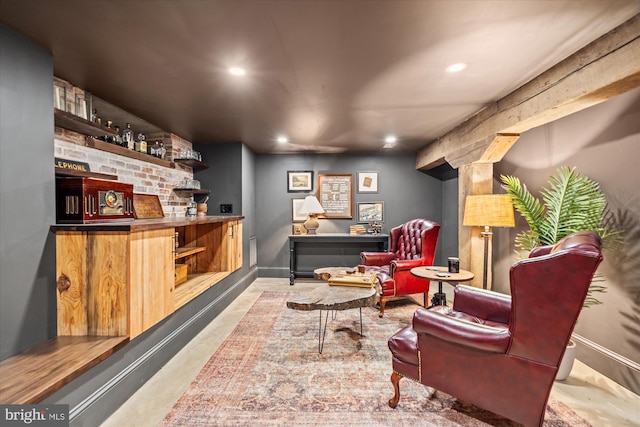 bar with recessed lighting, baseboards, a bar, and concrete flooring