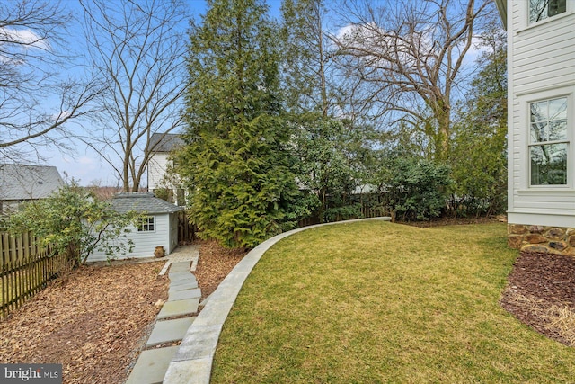 view of yard with an outbuilding, a storage unit, and a fenced backyard