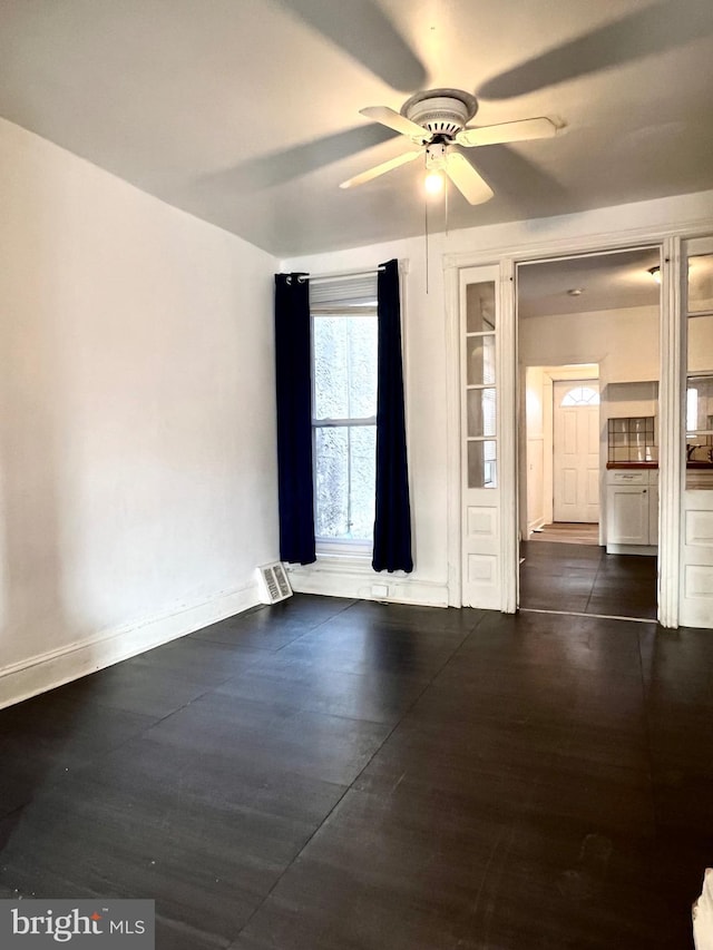 unfurnished room with ceiling fan and dark hardwood / wood-style flooring