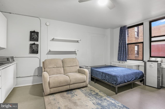 bedroom featuring ceiling fan, concrete flooring, and radiator