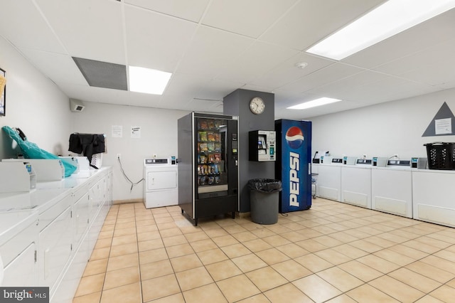 clothes washing area with light tile patterned floors and washing machine and clothes dryer