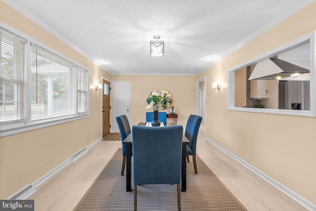 dining area with crown molding and wood-type flooring