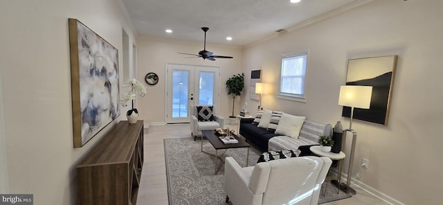 living room featuring ornamental molding, light hardwood / wood-style flooring, ceiling fan, and french doors