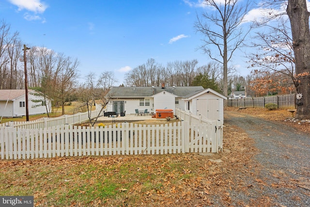 view of front of property with a hot tub and a storage unit