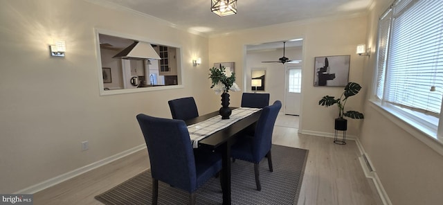 dining area with crown molding and light hardwood / wood-style floors