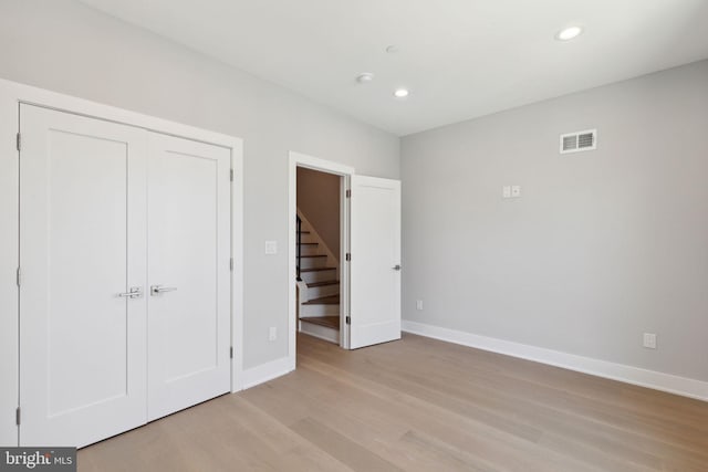 unfurnished bedroom with a closet and light hardwood / wood-style flooring