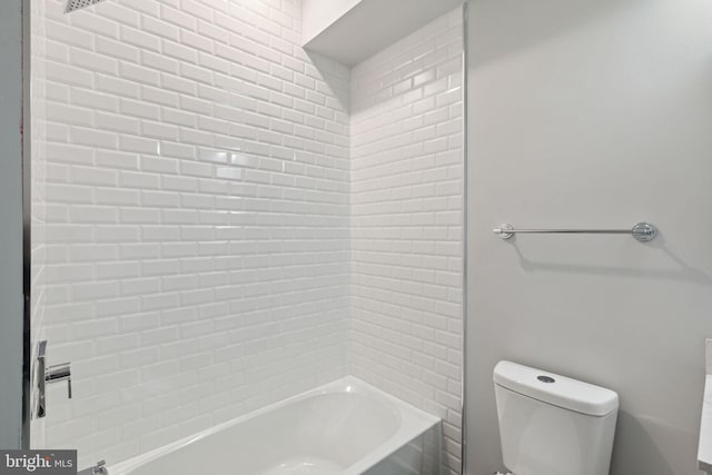 bathroom featuring tiled shower / bath combo and toilet