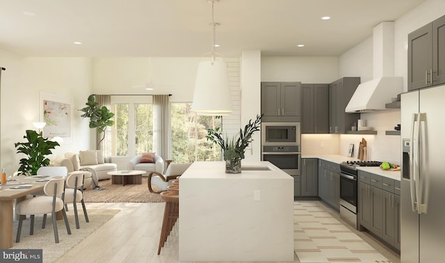 kitchen with a kitchen island, gray cabinetry, decorative backsplash, stainless steel appliances, and wall chimney exhaust hood