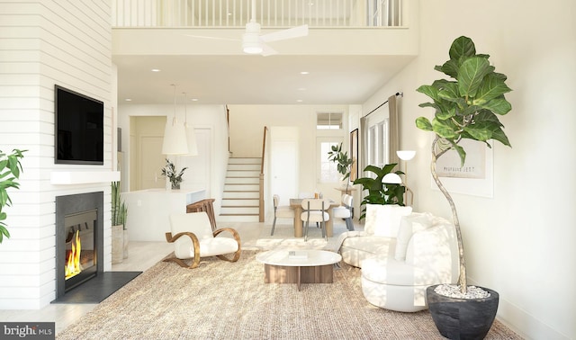 sitting room featuring a towering ceiling, a fireplace, and hardwood / wood-style floors