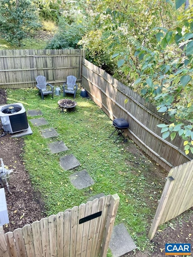 view of yard featuring a fire pit and central AC