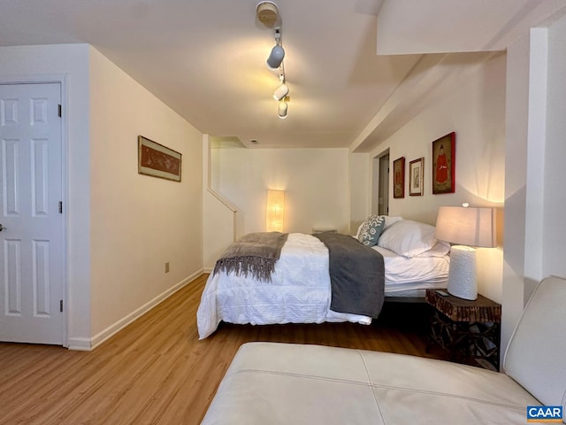 bedroom with hardwood / wood-style flooring and rail lighting