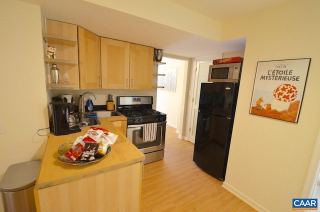 kitchen with appliances with stainless steel finishes, sink, light hardwood / wood-style flooring, and light brown cabinets