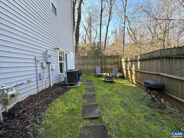 view of yard featuring cooling unit and an outdoor fire pit