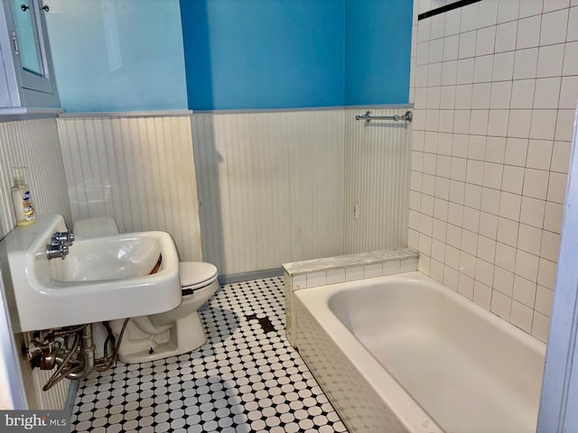 bathroom with sink, a bathtub, and toilet