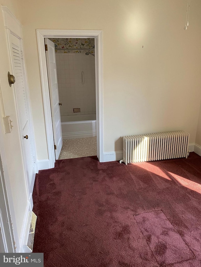 hall featuring radiator and carpet flooring