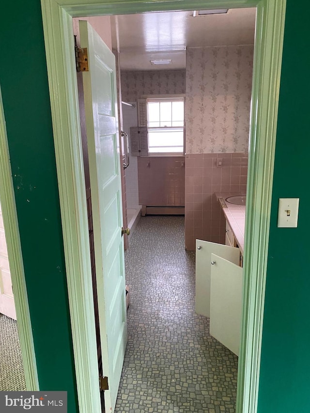 bathroom with tile walls and baseboard heating