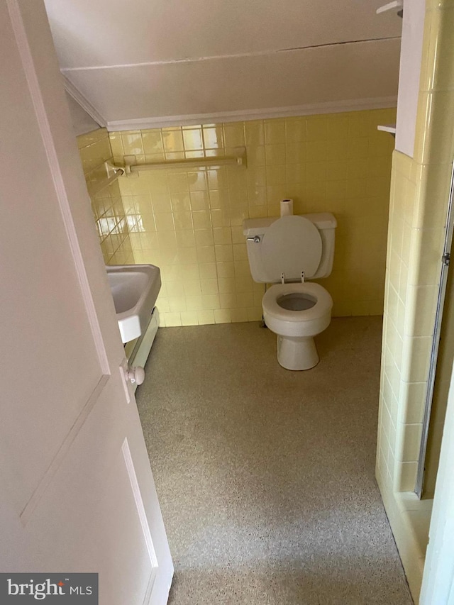 bathroom featuring tile walls and toilet