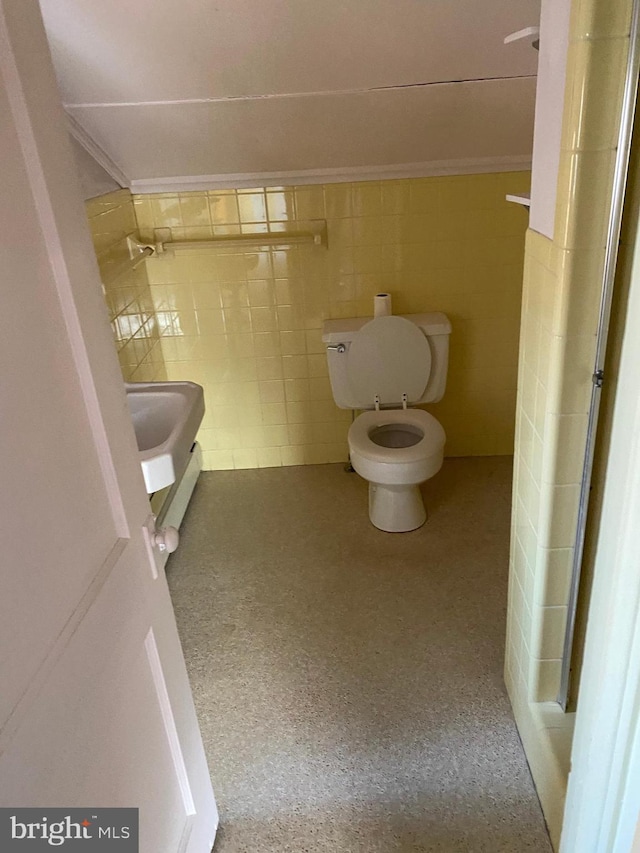 bathroom with toilet and tile walls