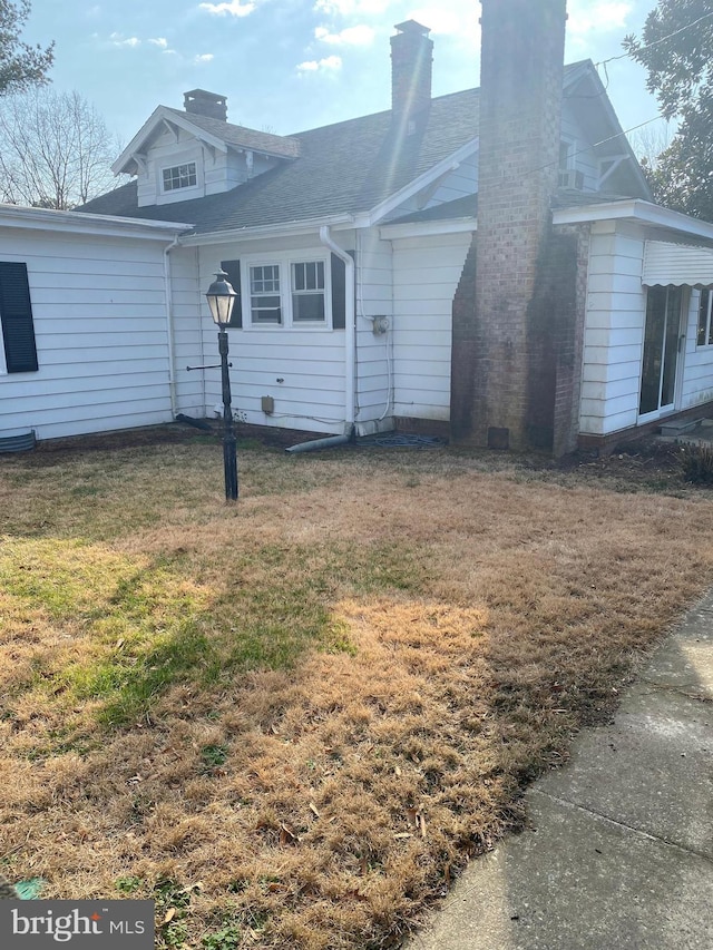 view of side of home with a yard