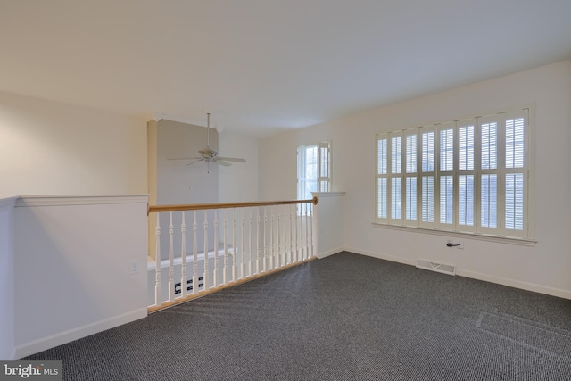 carpeted spare room featuring ceiling fan