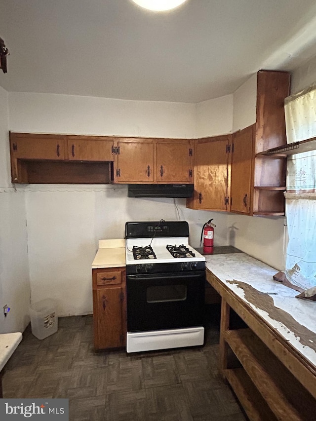 kitchen featuring dark parquet flooring and gas range oven