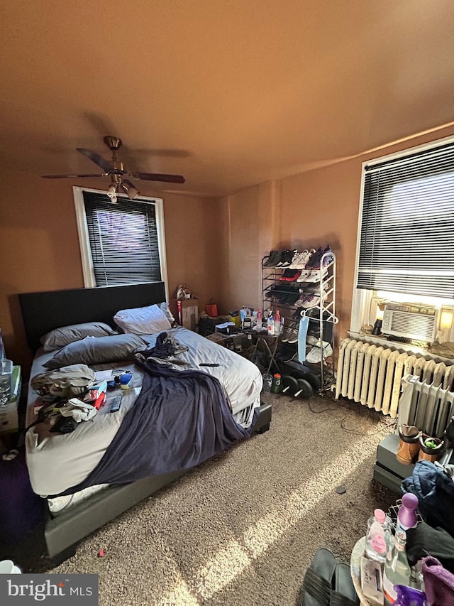 carpeted bedroom featuring radiator heating unit, ceiling fan, and cooling unit