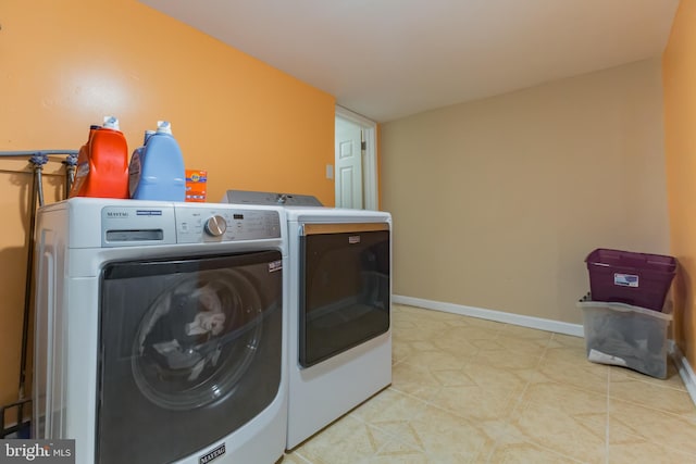 laundry room with washing machine and clothes dryer and light tile patterned flooring