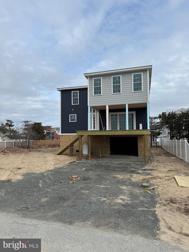 view of front facade with a garage, fence, and stairs