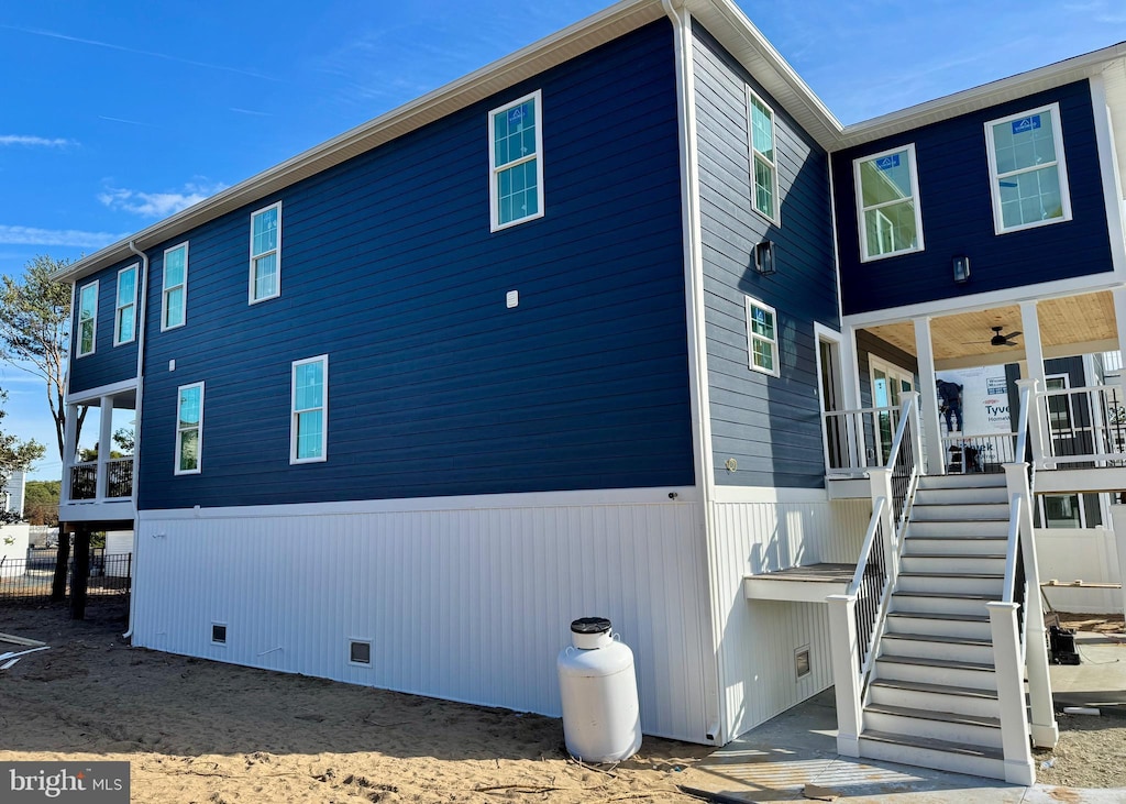 view of home's exterior with crawl space, covered porch, and stairway