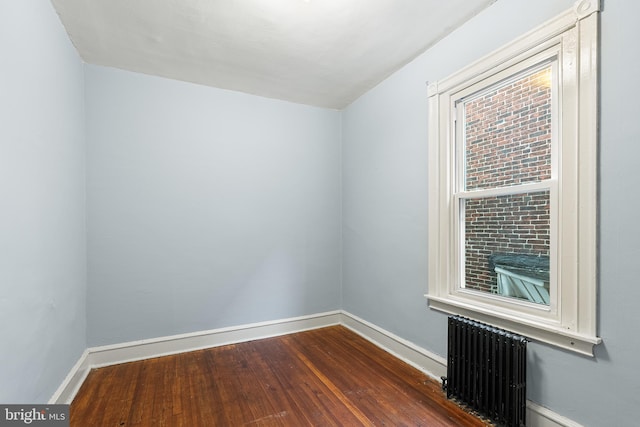 unfurnished room with radiator and dark hardwood / wood-style floors