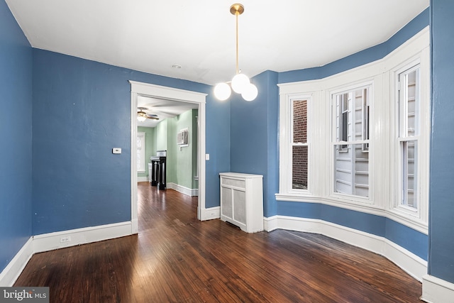 unfurnished dining area featuring a notable chandelier and dark hardwood / wood-style flooring