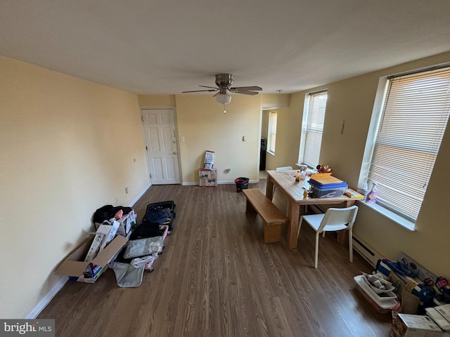 dining space featuring ceiling fan, dark wood-type flooring, and a baseboard radiator