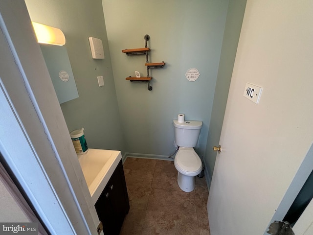 bathroom featuring vanity, tile patterned flooring, and toilet