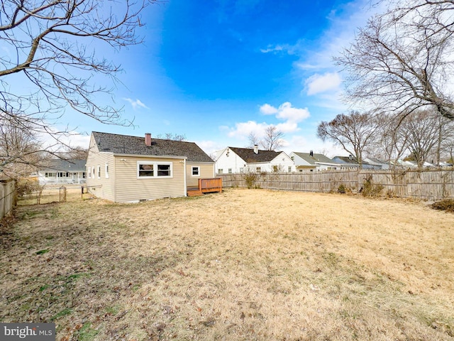 back of house with crawl space, a lawn, a chimney, and a fenced backyard