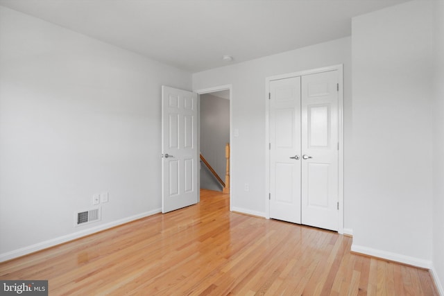 unfurnished bedroom with light hardwood / wood-style floors and a closet