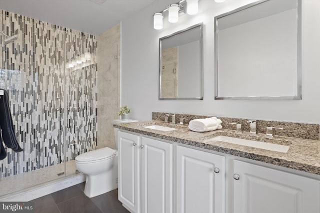 bathroom featuring tile patterned floors, vanity, toilet, and a shower with shower door